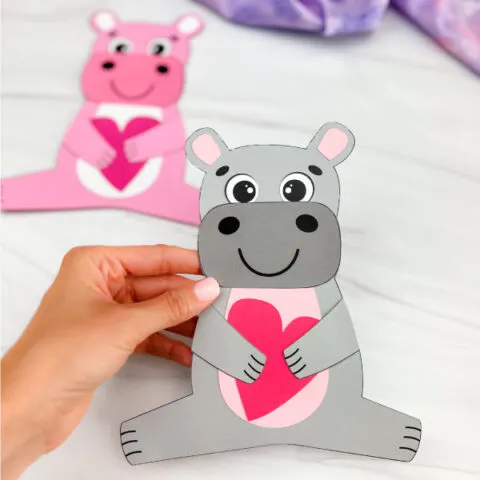 hand holding finished hippo valentine craft gray in color