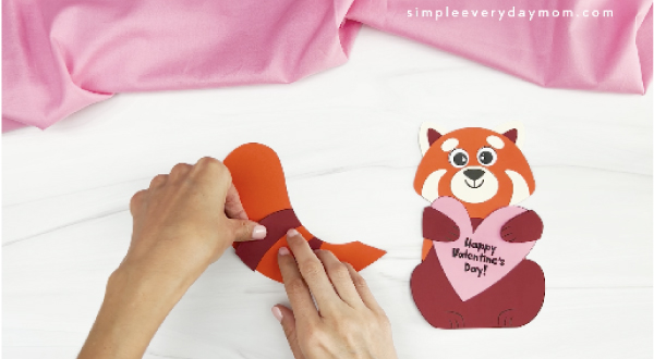 hands gluing stripes to red panda craft tail