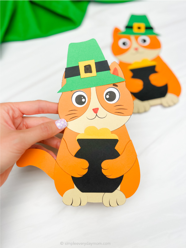hand holding cat leprechaun craft with another one in background
