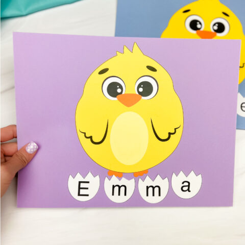 hand holding chick name craft with another in background