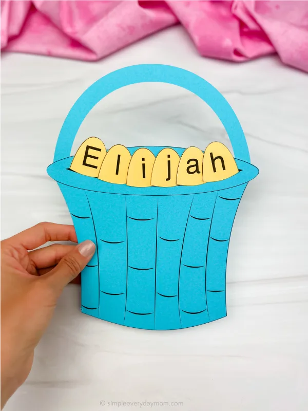 hand holding finished example of Easter basket name craft in teal