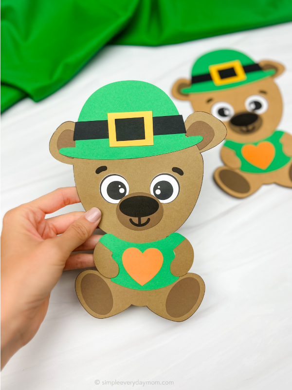 hand holding leprechaun teddy bear with another in background