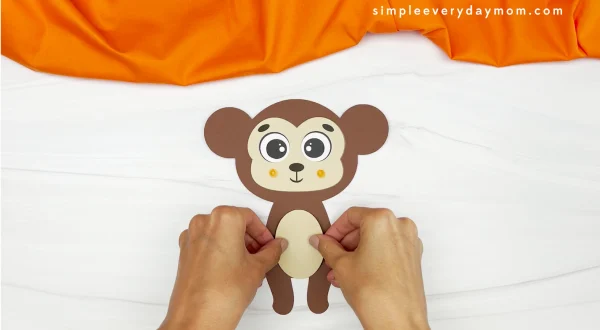 hands gluing monkey belly onto monkey body