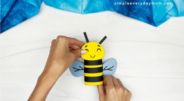 hands assembling bee face onto bee body