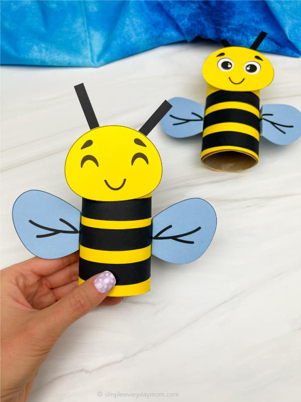 hand holding finished bee tp roll craft