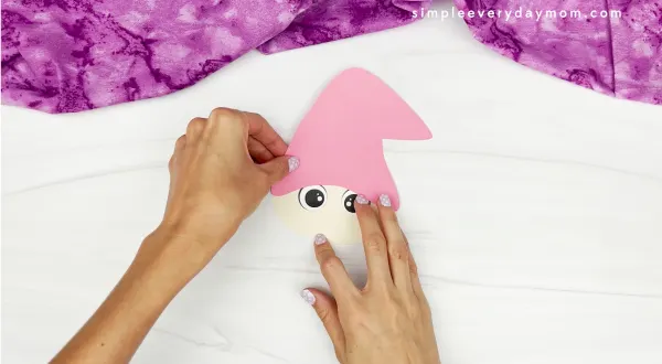 hands gluing gnome hat onto head of bunny gnome