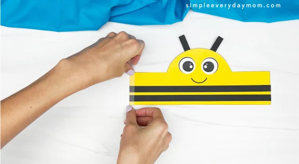 hands placing tape onto bee headband