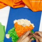 hands gluing tissue paper onto arms