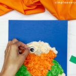 hands gluing eye to face of leprechaun