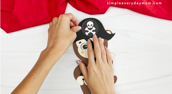 hand gluing pirate hat onto head