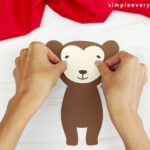 hands gluing face onto monkey