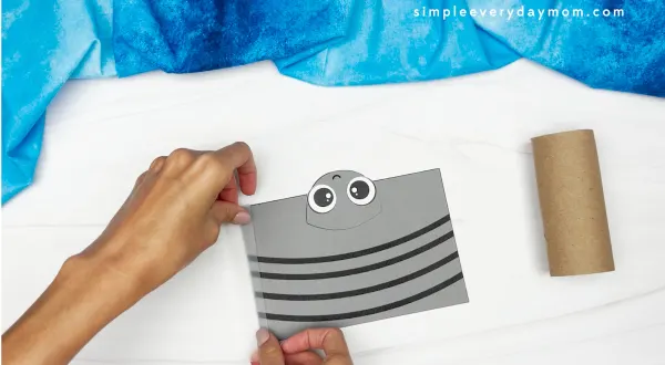 hands placing tape and end of paper