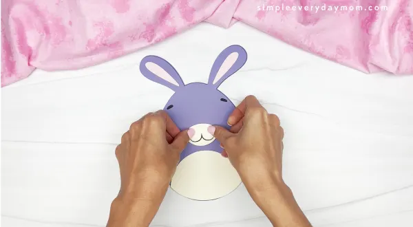 hands gluing nose onto Easter egg bunny