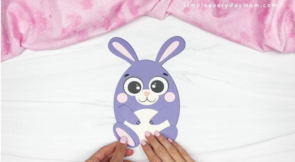 hands gluing parts of feet onto Easter egg bunny