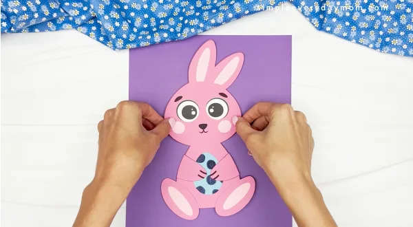 hands guing finished bunny onto purple background