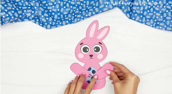 hands gluing bunny arms onto body