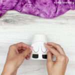 hands gluing sheep body onto cup