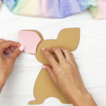 hands gluing ear onto mouse
