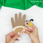 hands gluing quail legs onto body