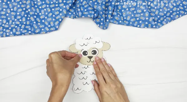 hands gluing sheep head to body