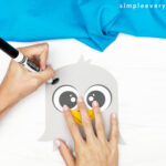 hands using black marker to draw onto eagle head
