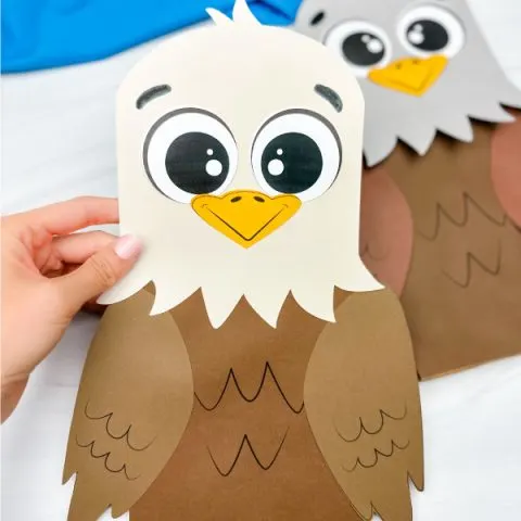 hand holding eagle paper bag puppet with another one in the background
