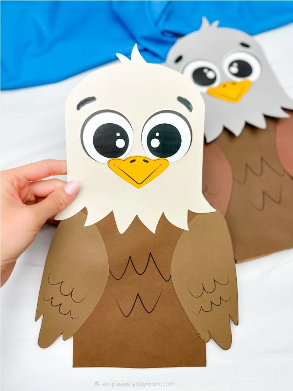 hand holding eagle paper bag puppet with another one in the background