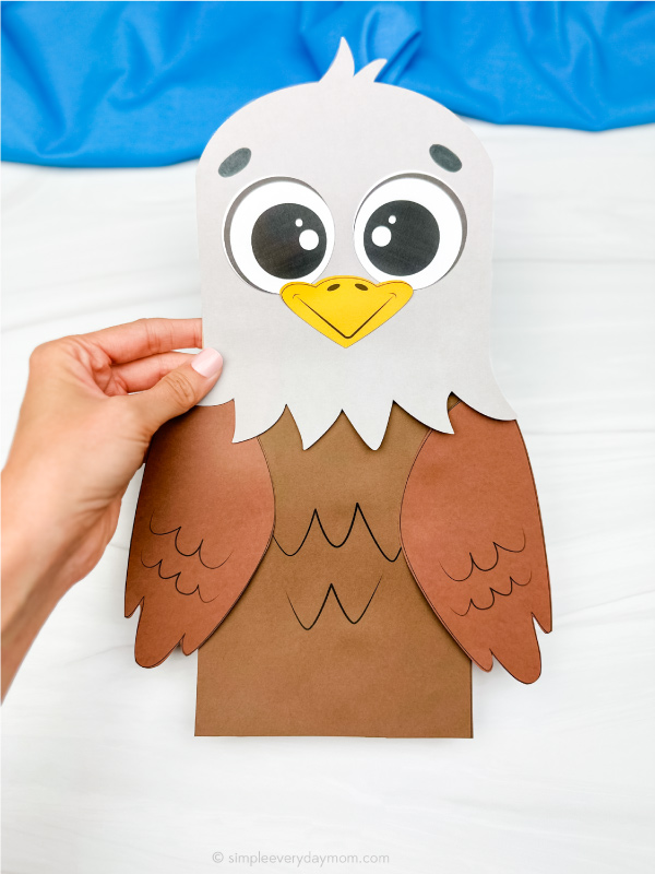hand holding eagle paper bag puppet