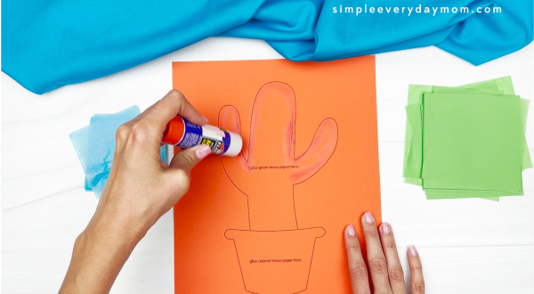 hand using glue stick to place glue onto cactus printed template