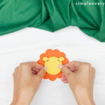 hands gluing lion face to mane