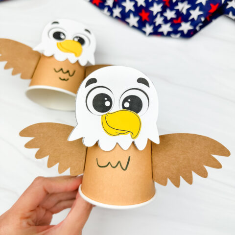 hand holding eagle paper cup craft with another example in the background