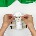hands gluing sheep face to body