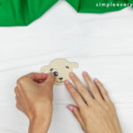 hands gluing eye to face of sheep