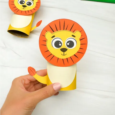 hand holding finished lion toilet paper roll craft with another in the background
