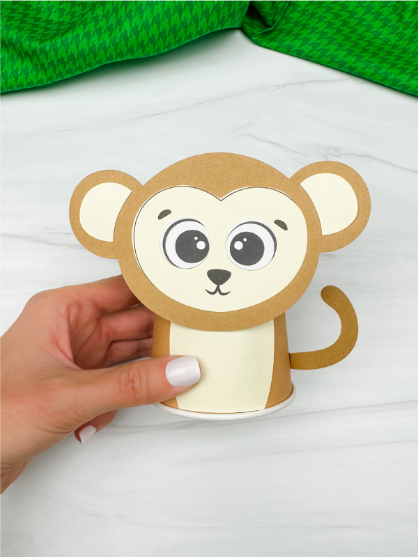 hand holding finished monkey paper cup craft