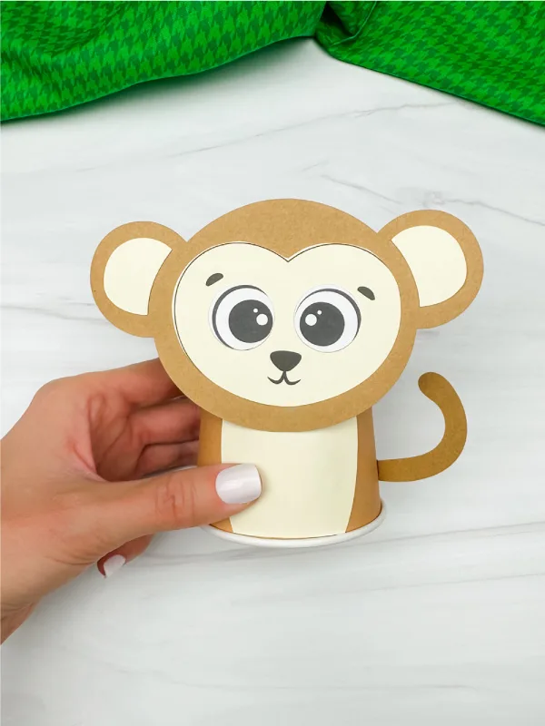 hand holding finished monkey paper cup craft