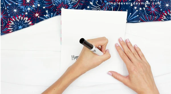 hand using black marker to write a note inside card