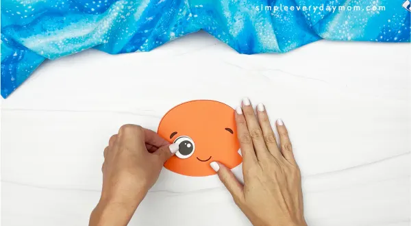 hand gluing eye onto jellyfish head
