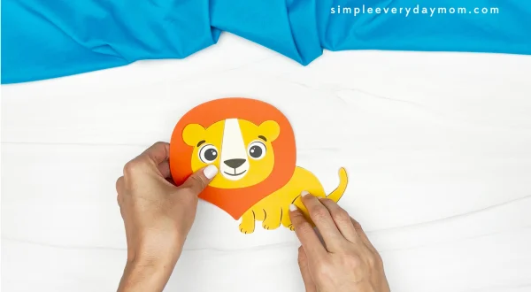 hands gluing lion face to body of lion