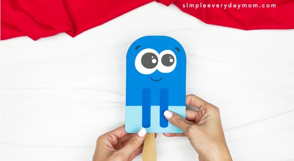 hands gluing popsicle stick onto popsicle