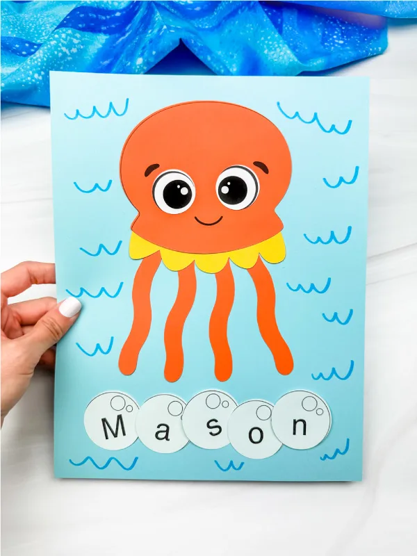 hand holding finished jellyfish name craft for kids