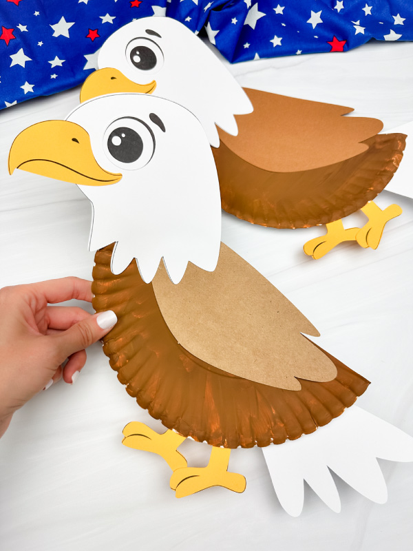 hand holding eagle paper plate craft with another example in background