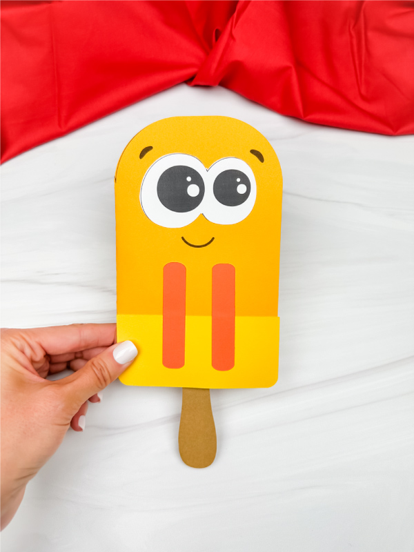 hand holding single example of popsicle stick fathers day card