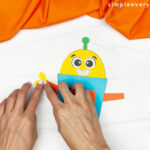 hands gluing robot arms and hands onto robot body