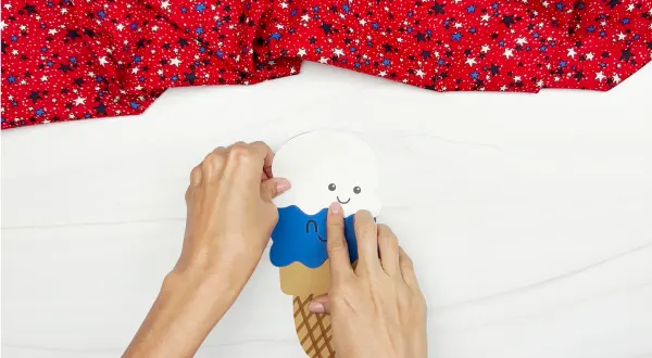 hands gluing white ice cream on top of blue ice cream