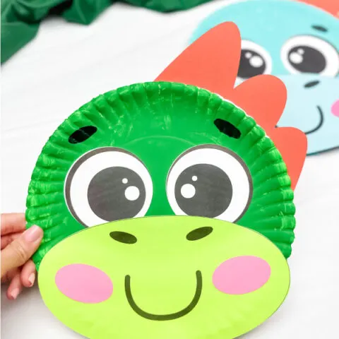 holding the dinosaur paper plate craft with background