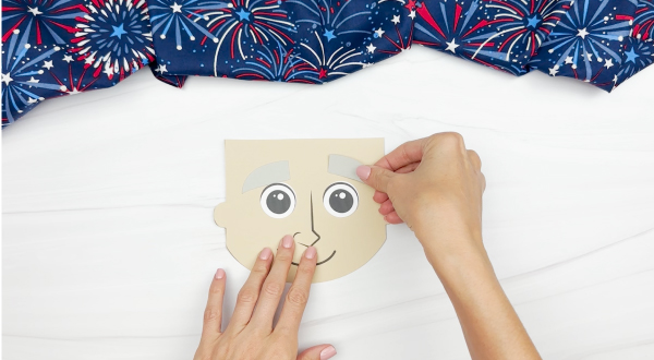 hands gluing eyebrow to Uncle Sam puppet craft