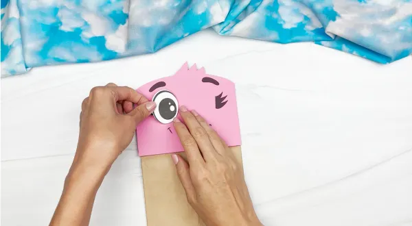 hands gluing eyes to flamingo face