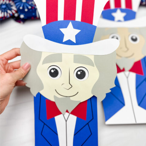 hand holding Uncle Sam puppet craft with a 2nd one in the background