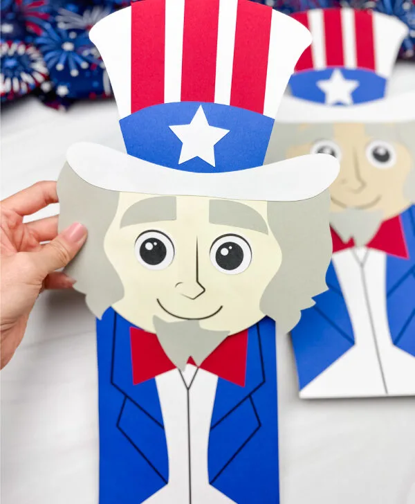 hand holding Uncle Sam puppet craft with a 2nd one in the background